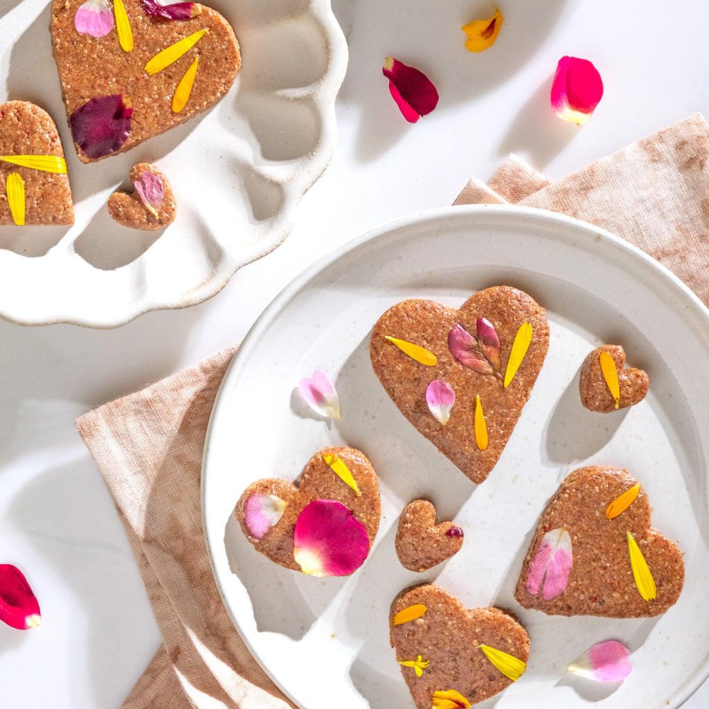 Top view of heart shaped no-bake cookies on white plates with flowers