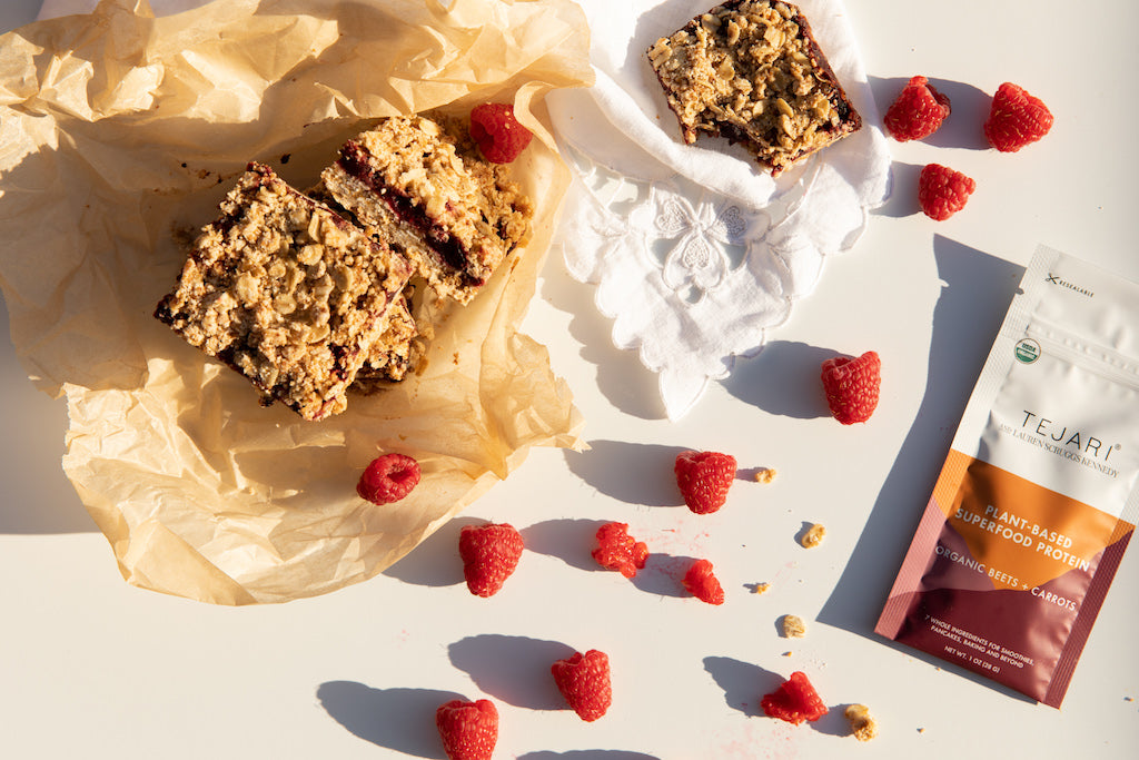 top view of vegan raspberry oat bars on white surface with package 
