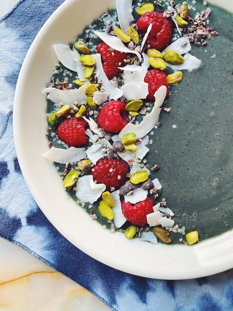 Top view of blueberry yogurt bowl in white bowl with berries and coconut