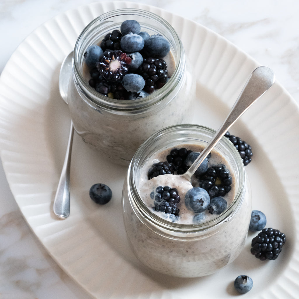 Two vegan chia pudding jars topped with berries