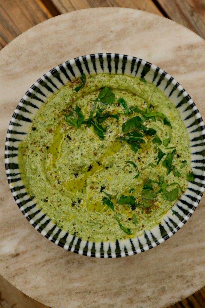 bowl of lemon herb tahini hummus without chickpeas with herbs