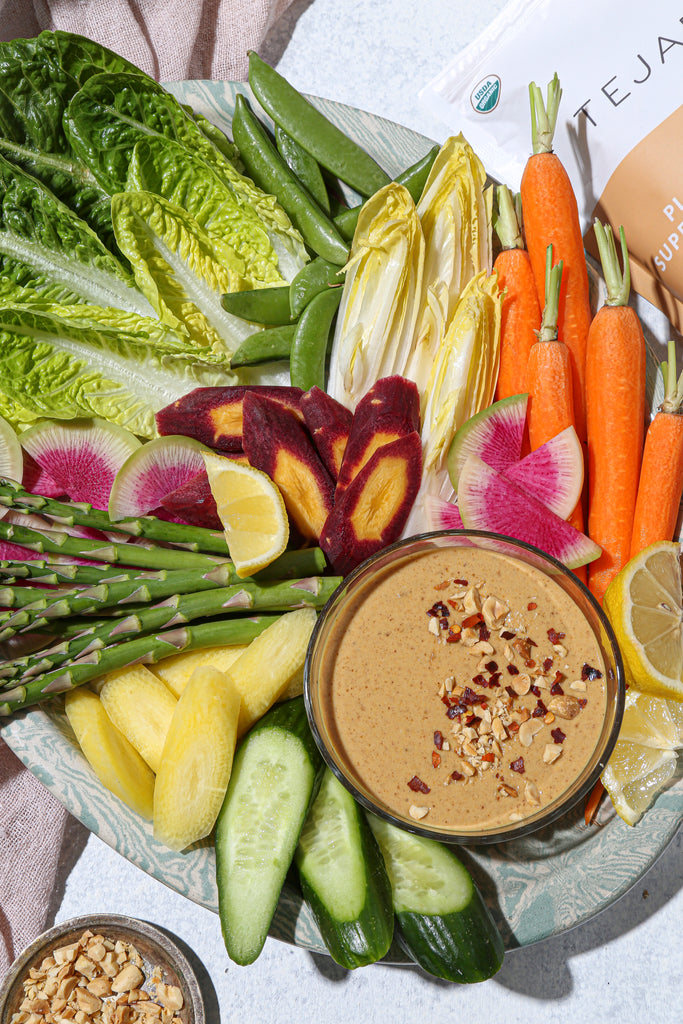 Top view of veggies with spicy peanut sauce in bowl