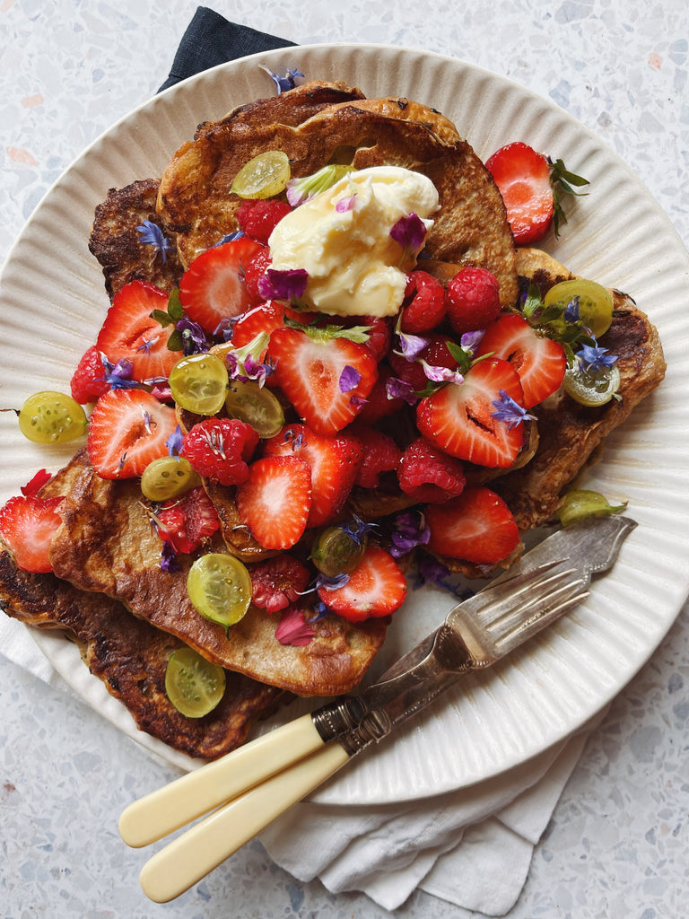 top view of French toast with fruit on white plate