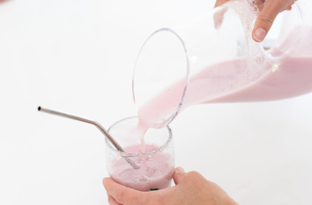 strawberry yogurt smoothie in glass with straw