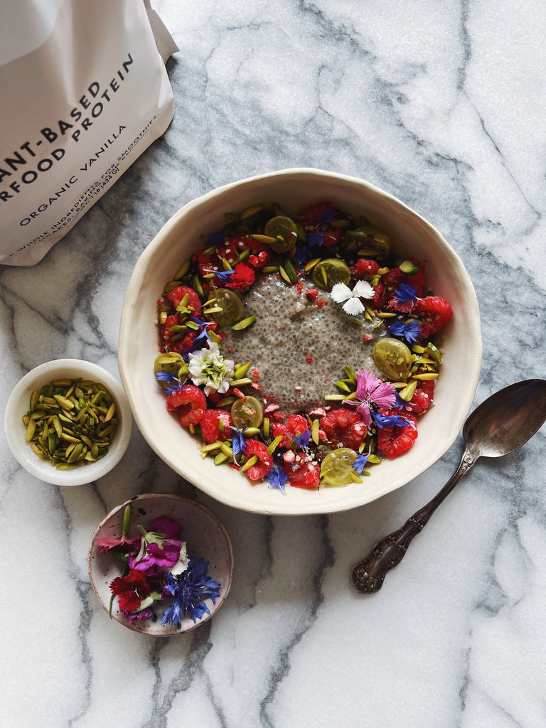 Bowl and Spoon with Organic Yogurt with Mixed Fruit Edible Flowers and Seeds