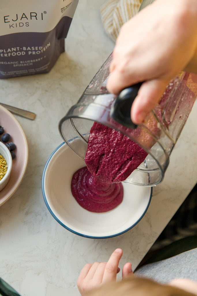 Organic Blueberry Being Poured from a Blender into a White Bowl