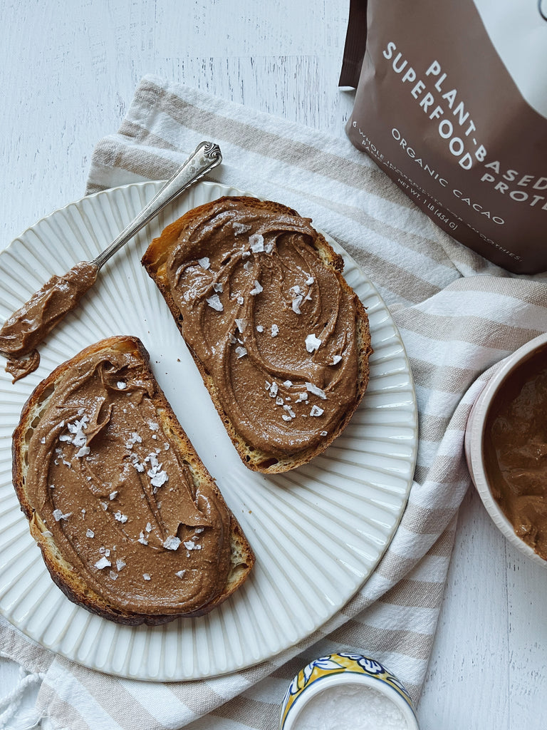 Smear Made From Organic Cacao on Toast Shown on a White Plate and Knife