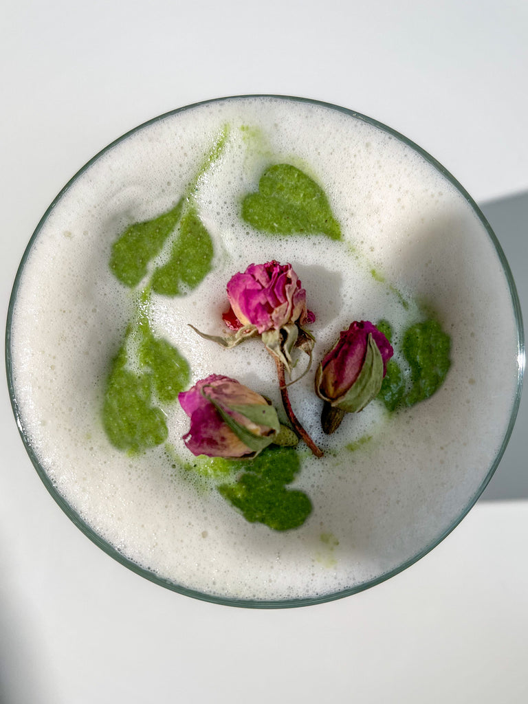 Looking From Top Down an Alternative Smoothie White Foam with Green Apple Designs and Some Flower Petals 