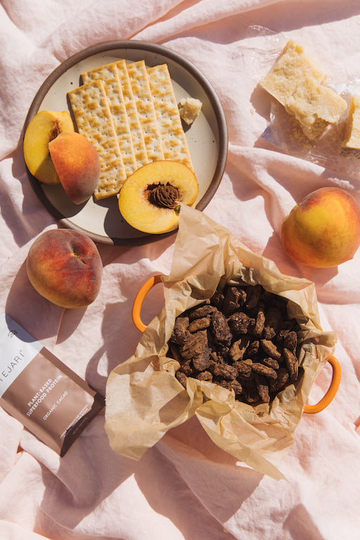 Delicious Setting with Peaches Whole and Sliced in a Table Top Picnic Setting and a Basket of Raw Cacao